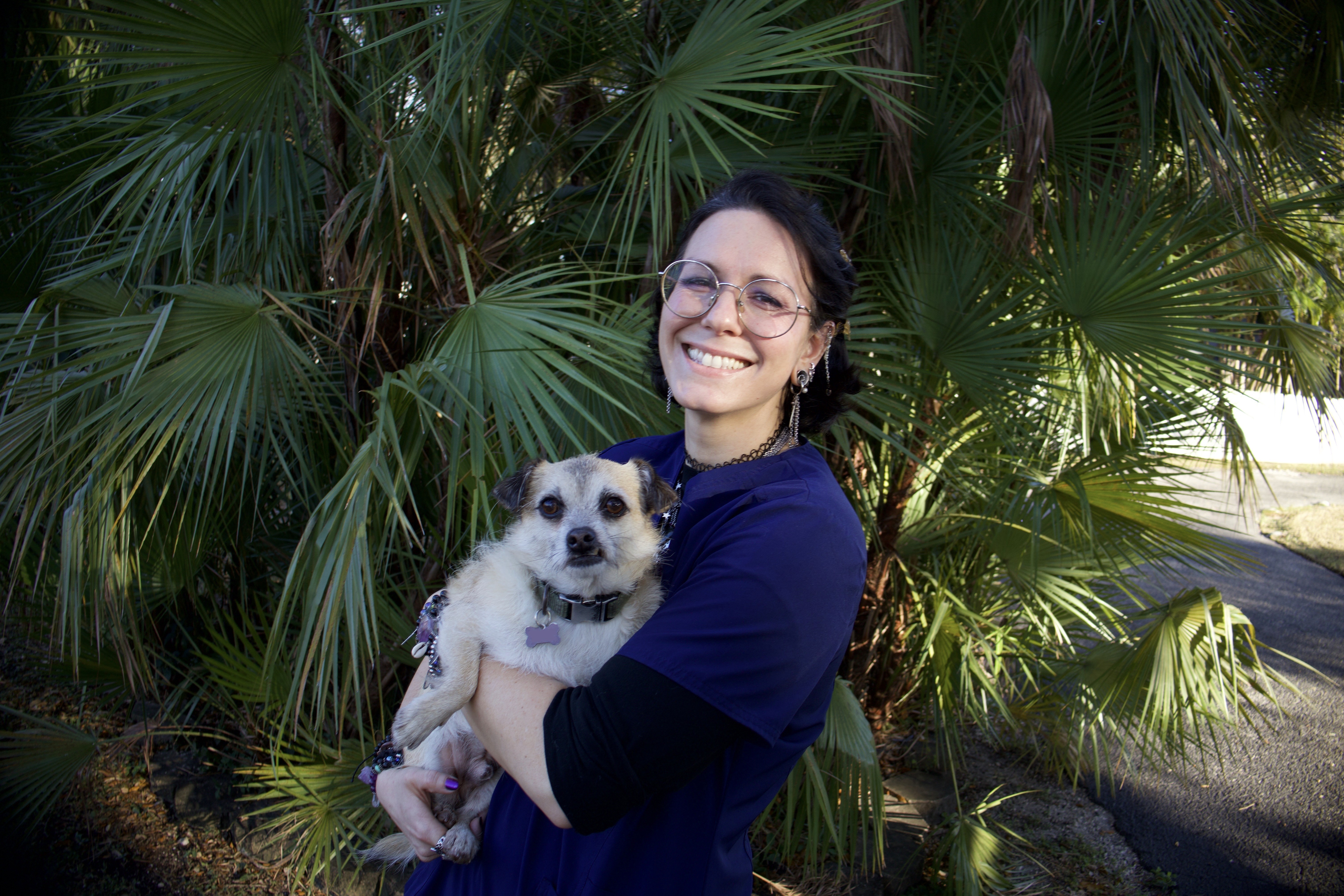 kim in front of greenery holding a terrier mix
