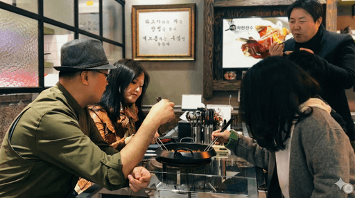 Close-up of lush, dark green leaves, some glossy and wet, against a muted background.