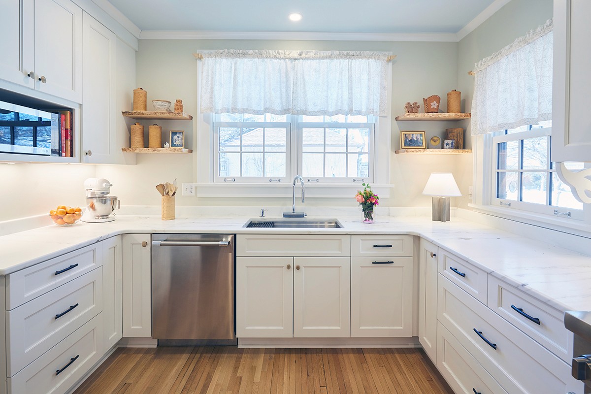 White Shaker cabinetry, marble countertops, and floating wood shelves in the Linden Hills kitchen