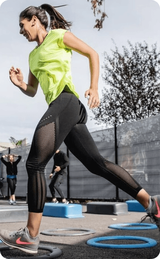 woman wearing a green shirt and nike shoes running