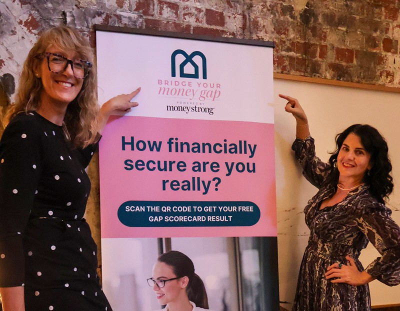 two women point to a sign that reads "Money Strong, How Financially secure are you really?"
