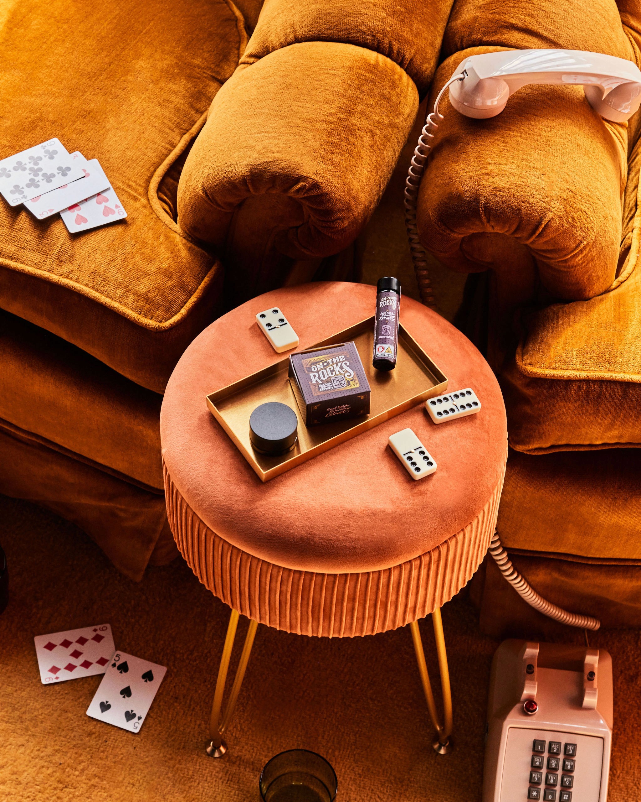 A tan sighthound stands in a grassy field.