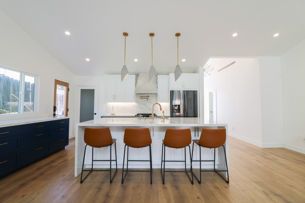 navy blue and white shaker kitchen with oak floors and custom hood