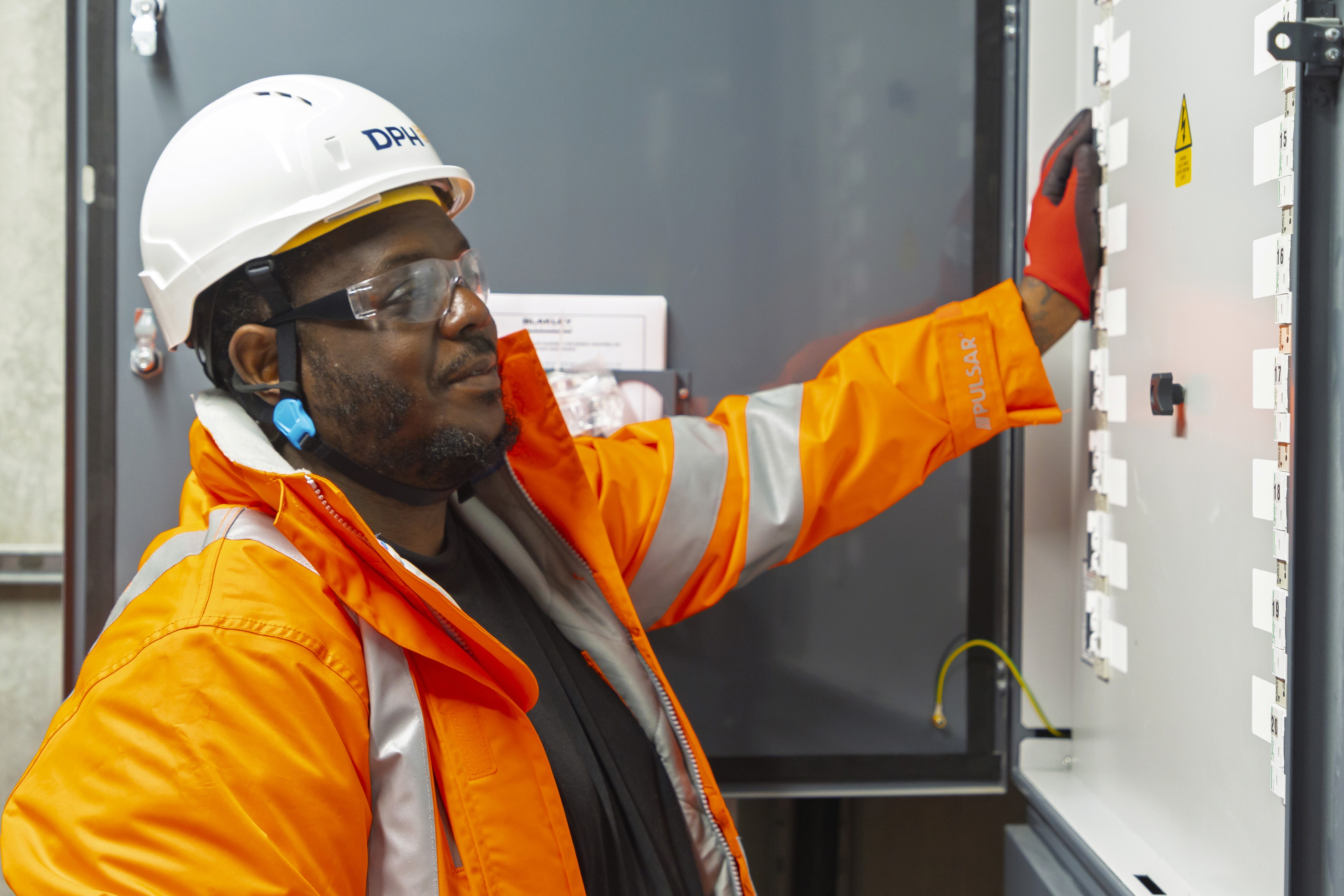 Modern glass building with illuminated interior and reflections at sunset