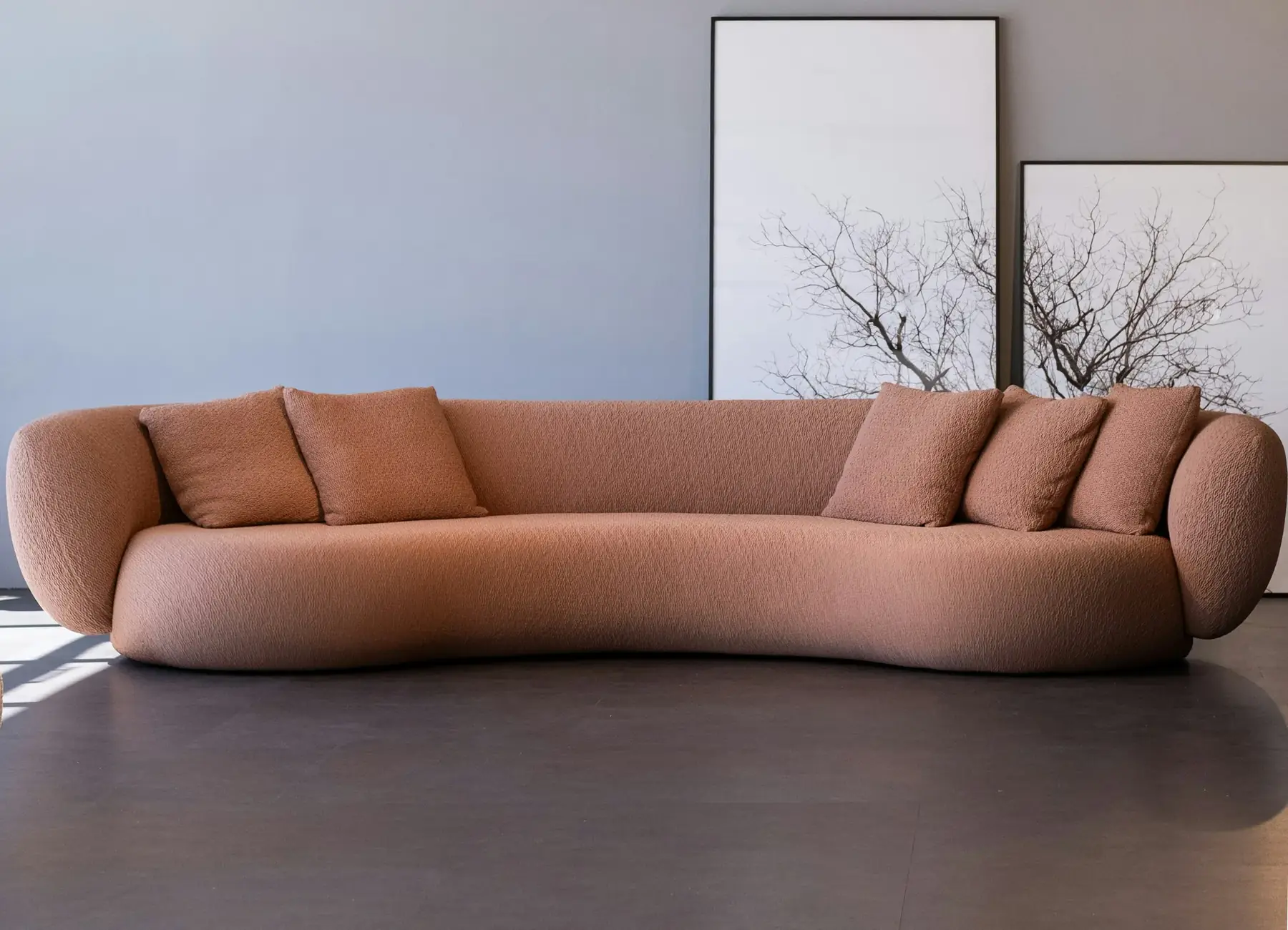 A curved terracotta bouclé sofa on the showroom floor
