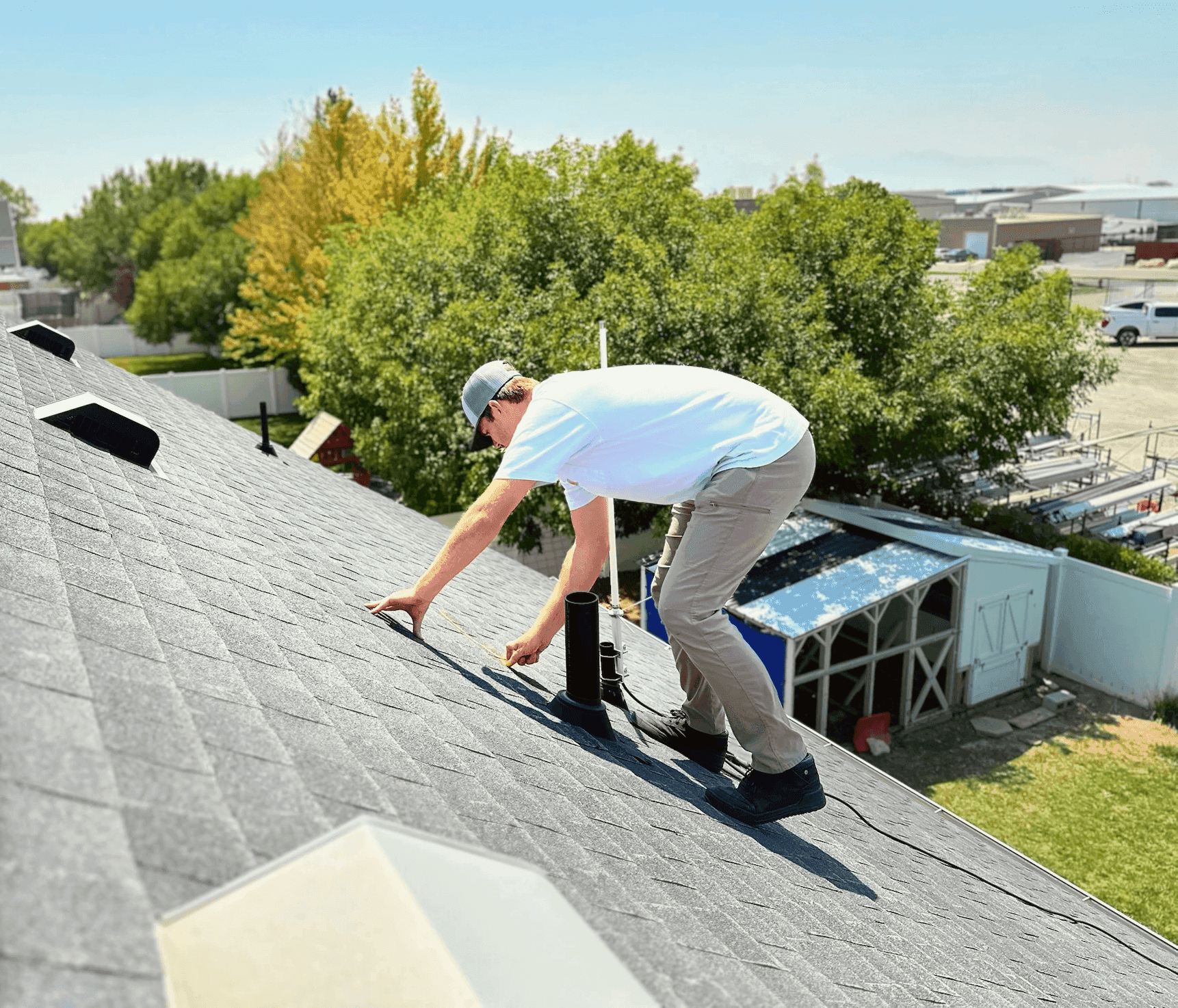 Roofing technician measuring a roof vent pipe during a repair in Salt Lake City