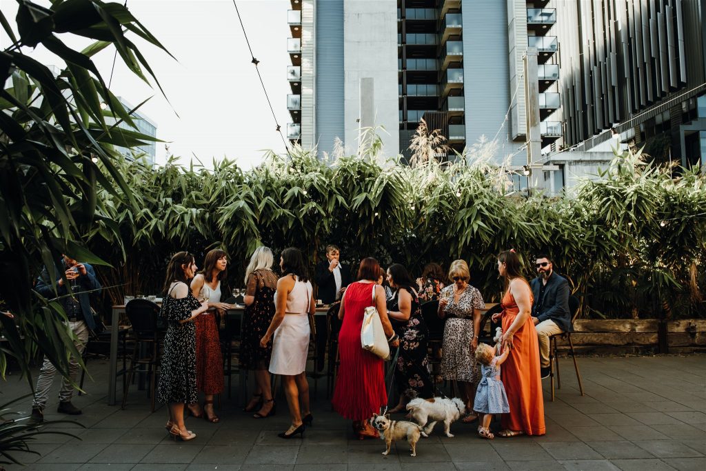 Guests mingling around a table in an outdoor courtyard