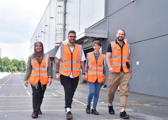 Professionals working in an industrial logistics environment representing international experience with companies such as Amazon and Adecco, featured in Alessandro Brancati Boutique Advisory Studio