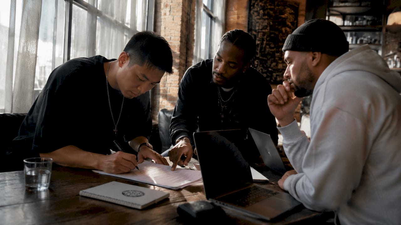 Group signing split sheet in studio
