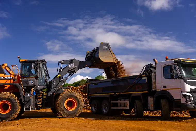Excavators and dump trucks carrying out bulk earthworks and drainage installation on a large-scale civil engineering infrastructure project.