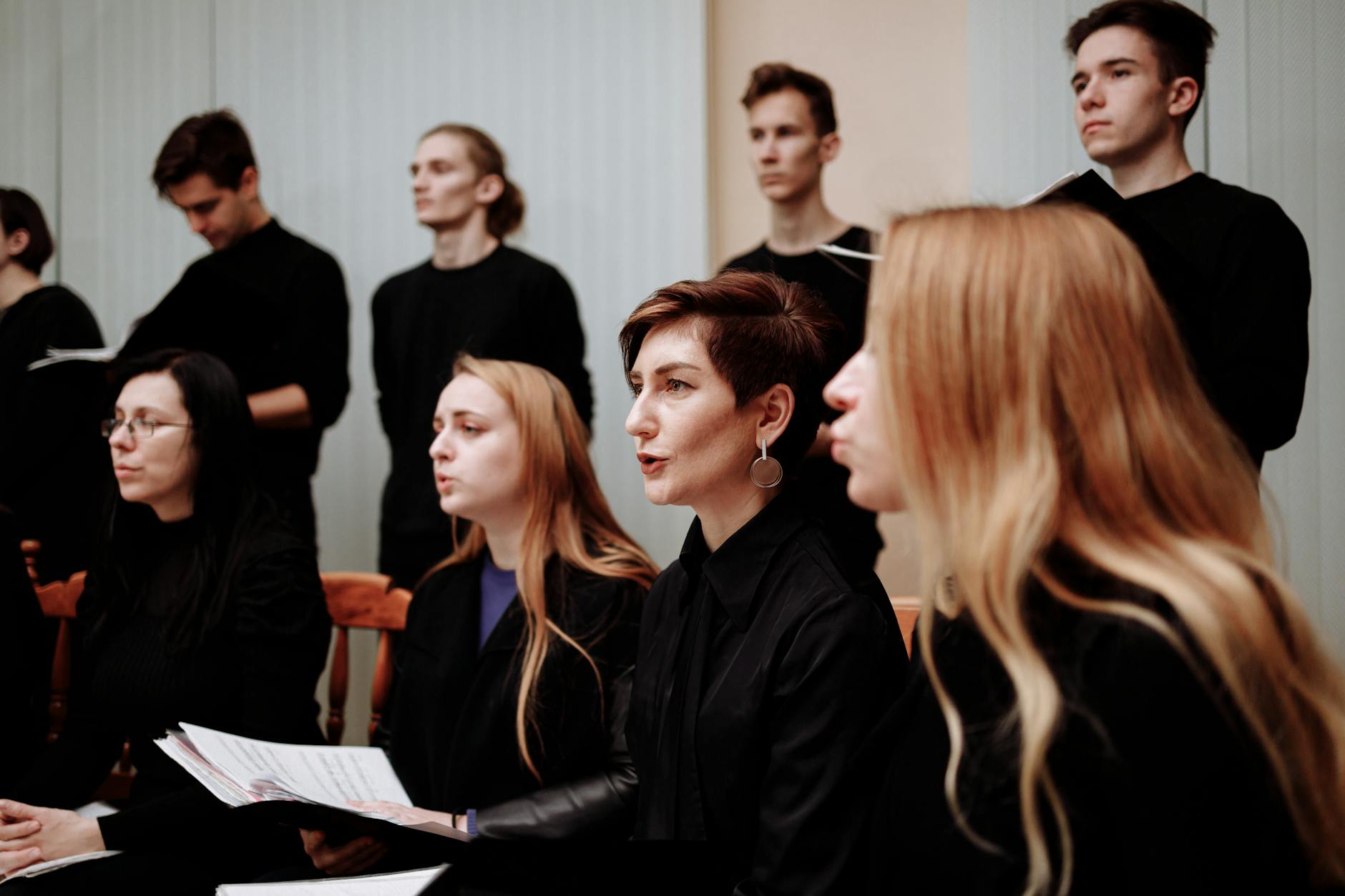 A vocal coach providing real-time feedback to a young performer during a private lesson in a professional studio.