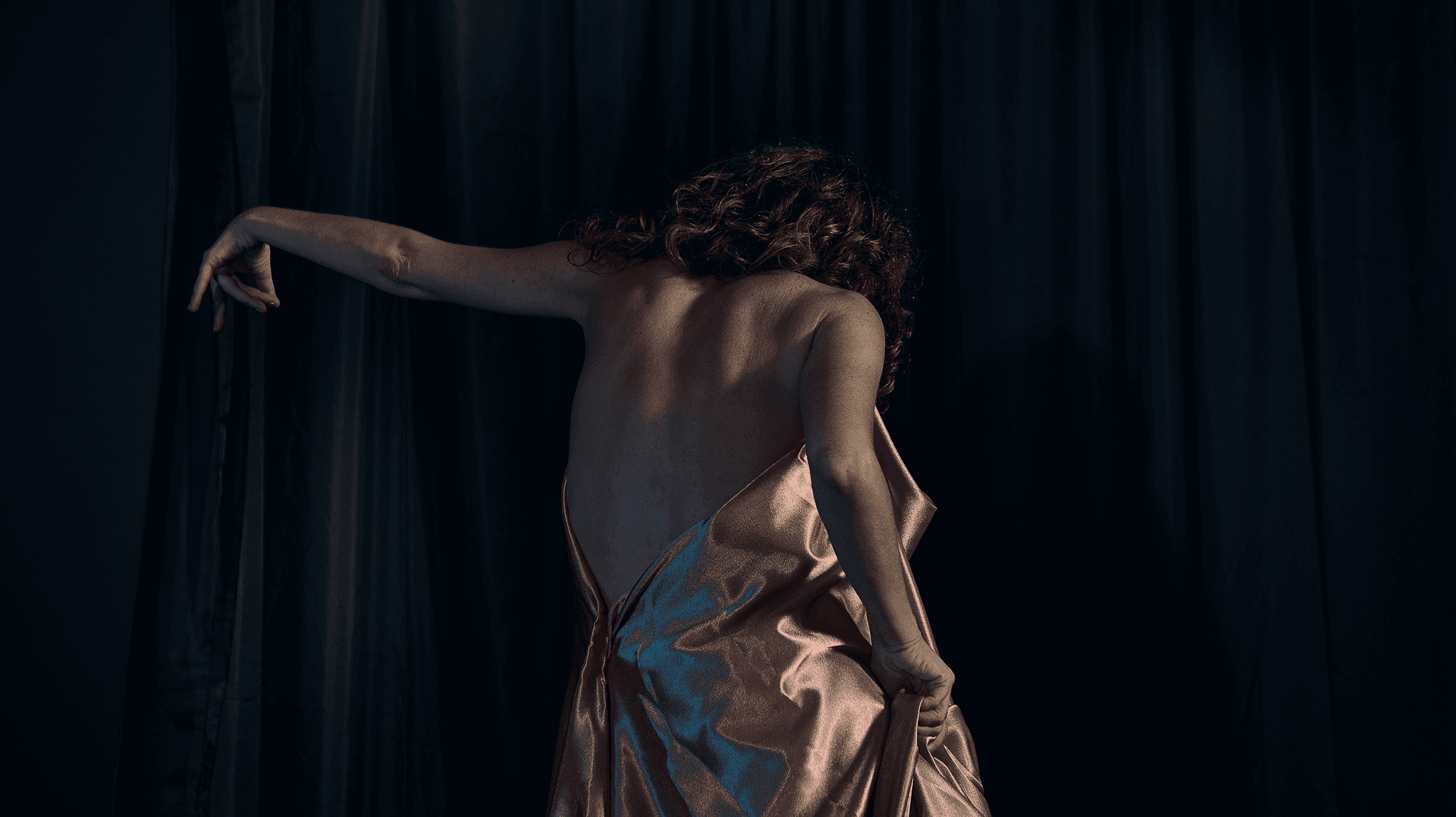 Dancer captured mid performance with artistic and expressive movements against a dark background.