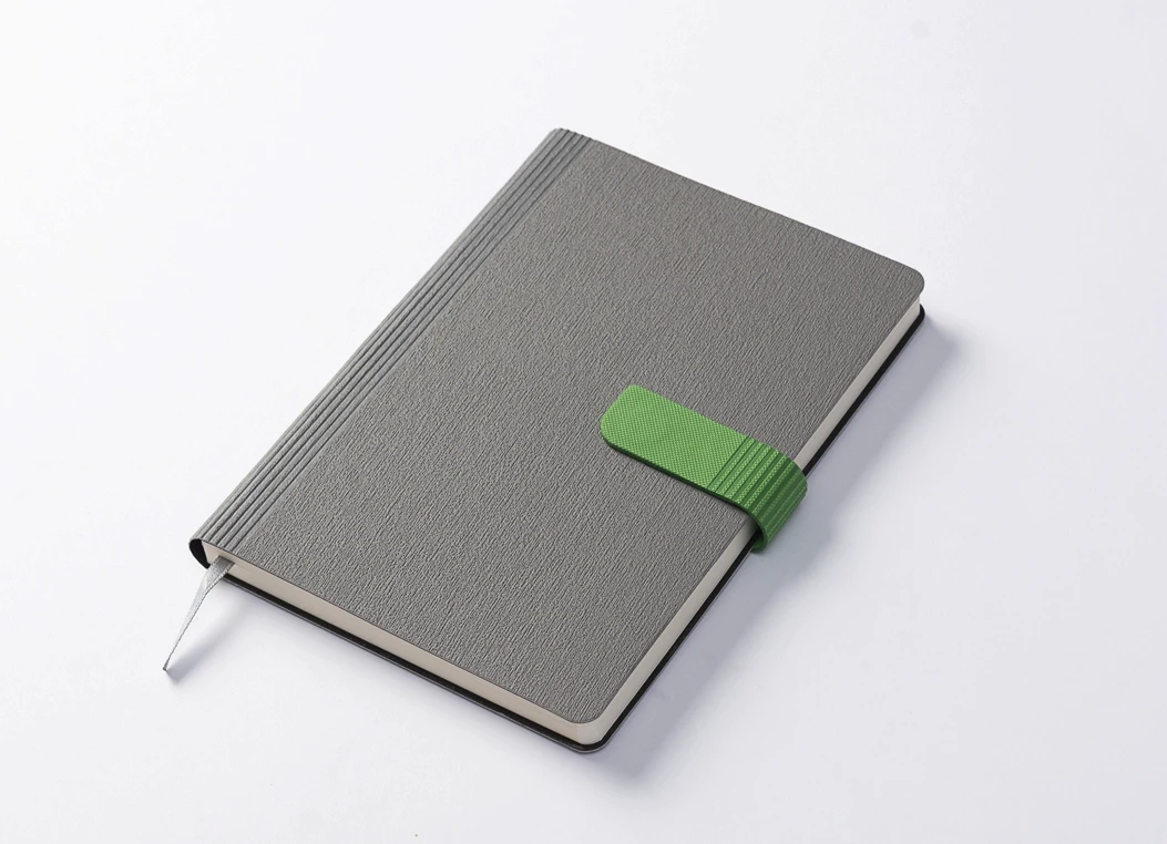 Angled view of grey journal with green strap closure