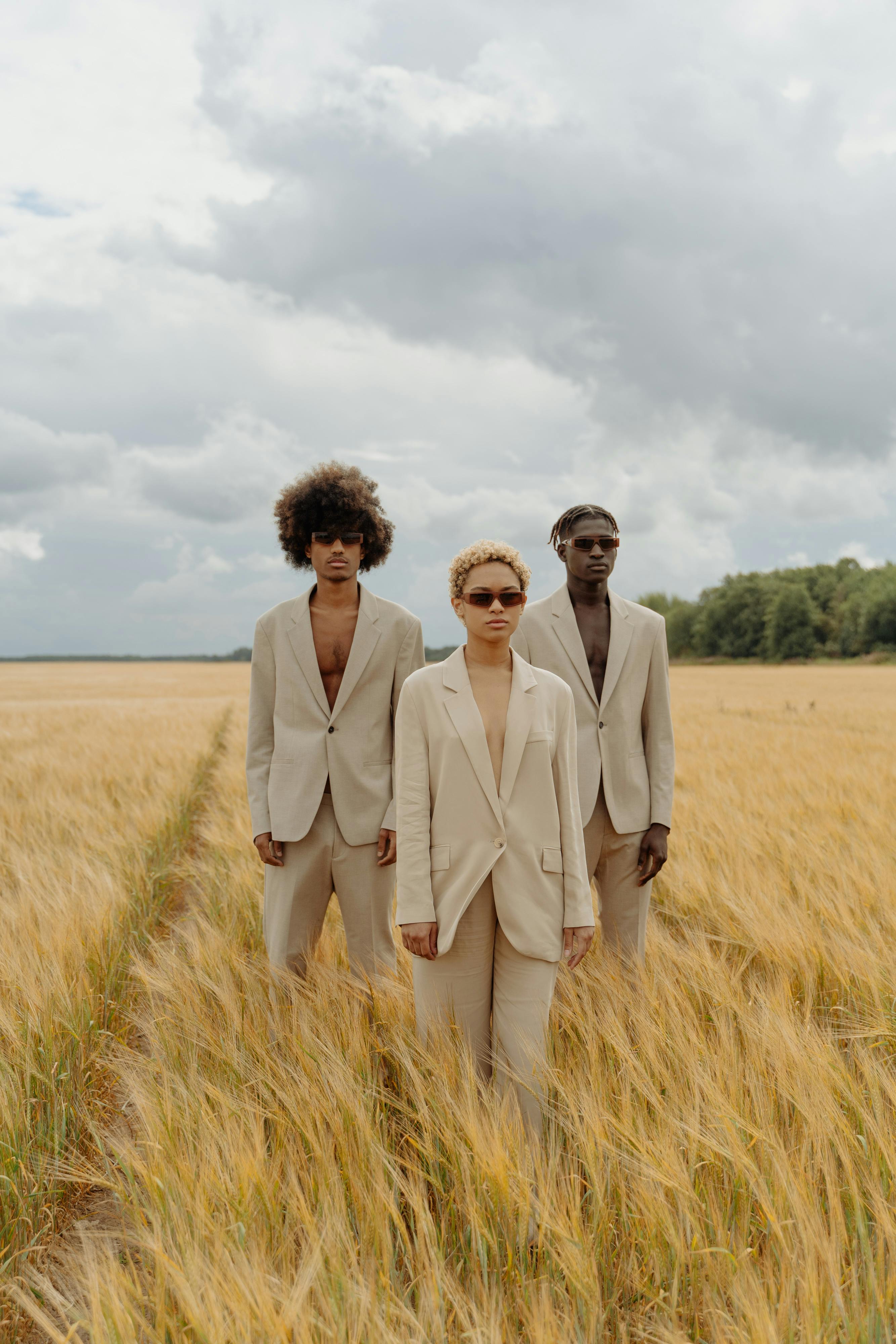 Three people in a field wearing white suits