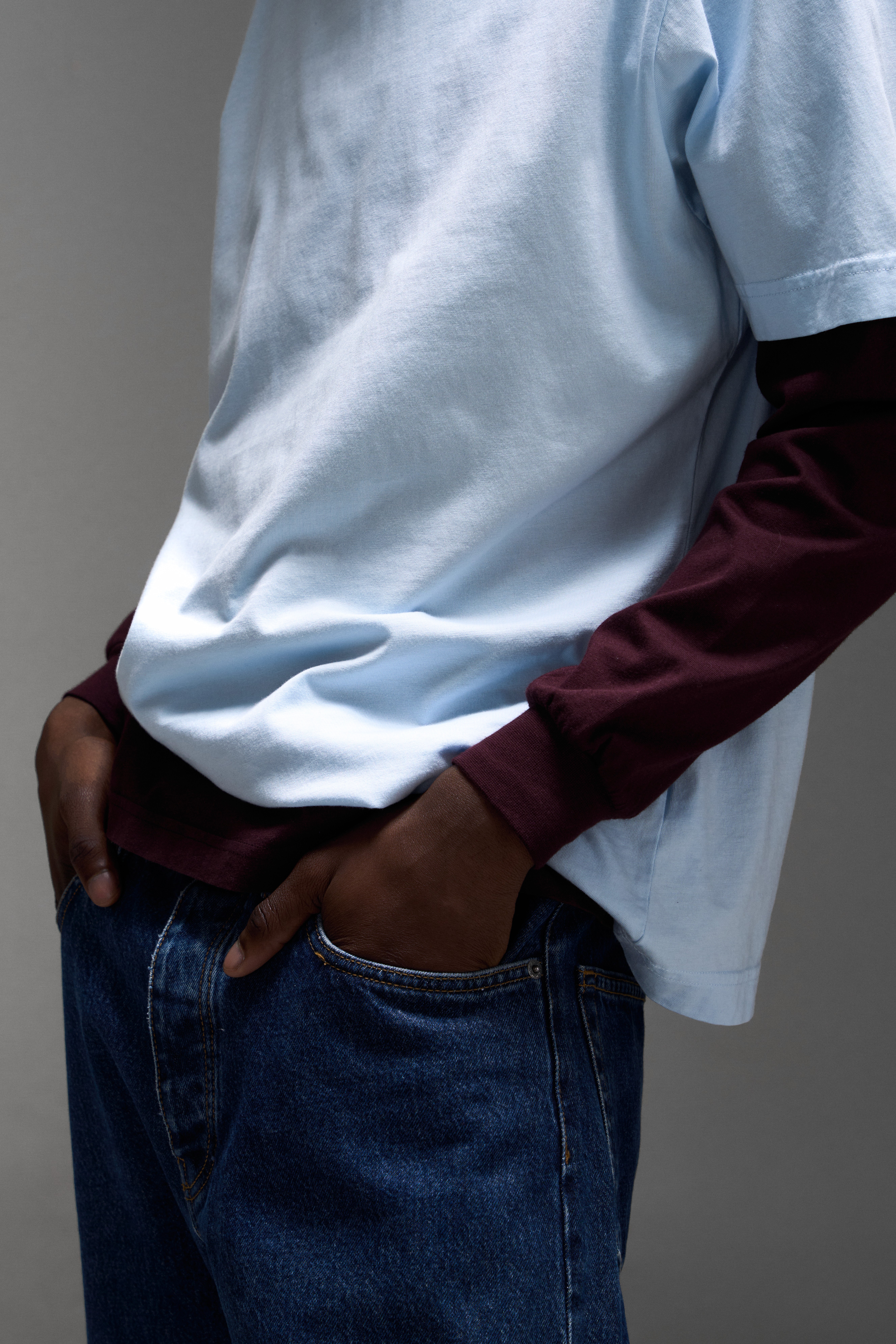 Détail du lookbook Colorful Standard avec superposition de t-shirts bleu et bordeaux