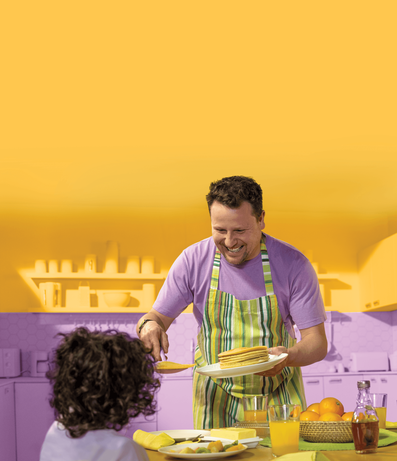 man serving pancakes to a child