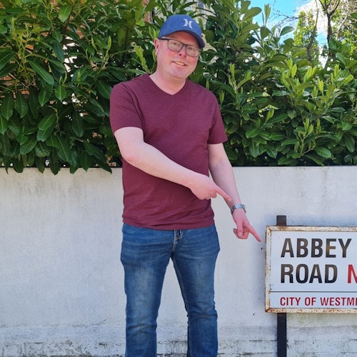 A man standing, pointing to the roadside