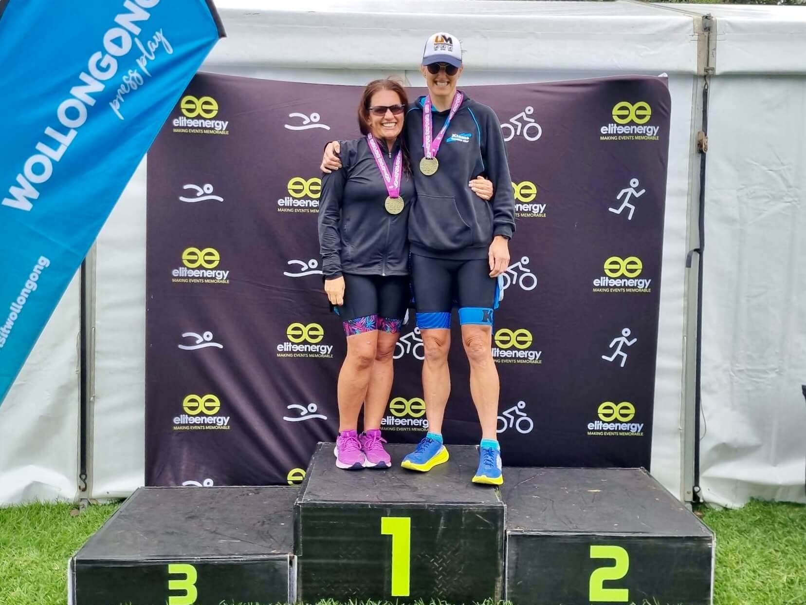 Lily and Jay standing on first place podium at NSW State championships wearing their gold medals