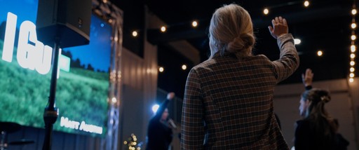 a woman standing in front of a crowd holding a microphone