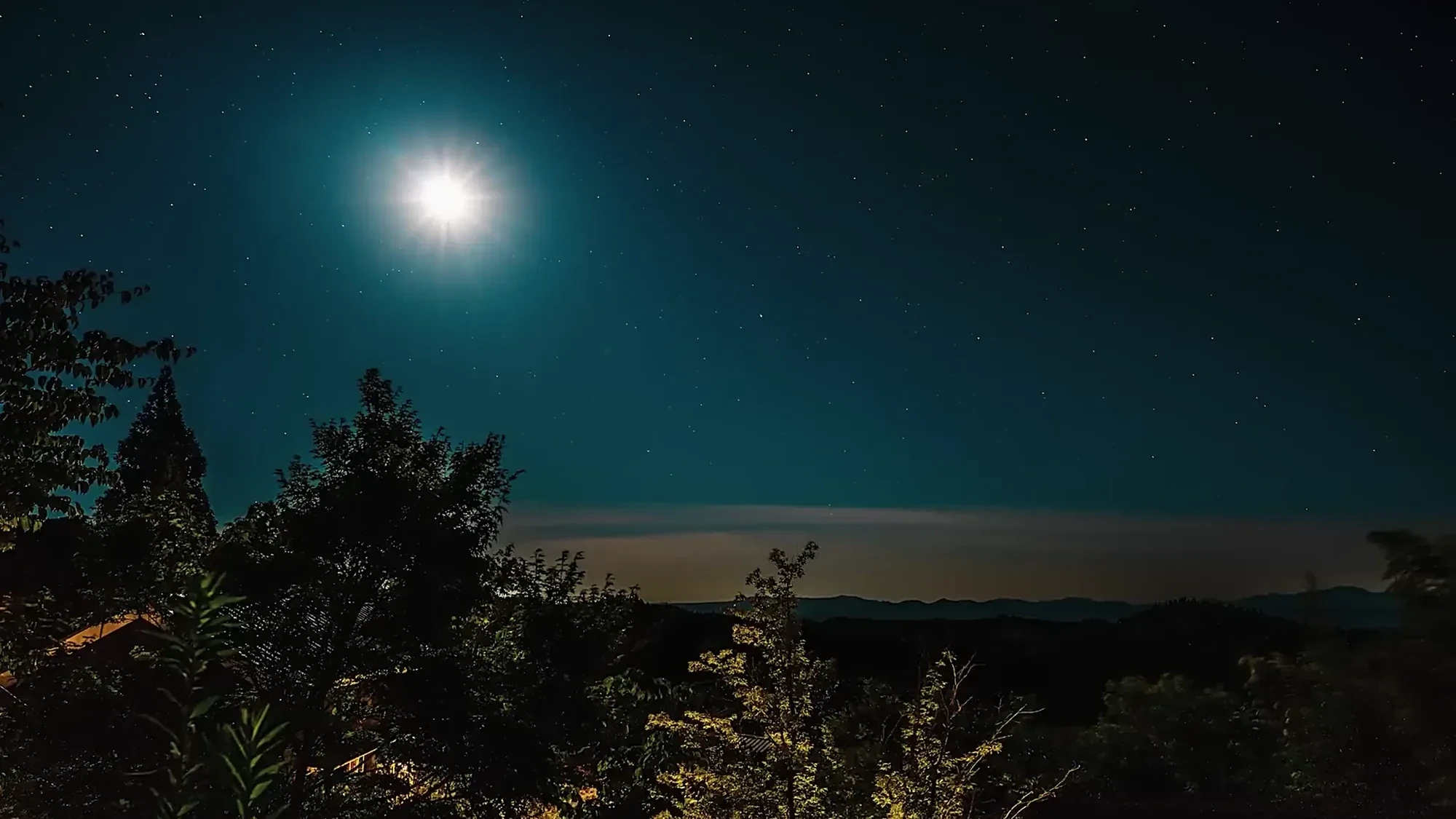 A full moon over the ridge above Kurokawa Onsen at night