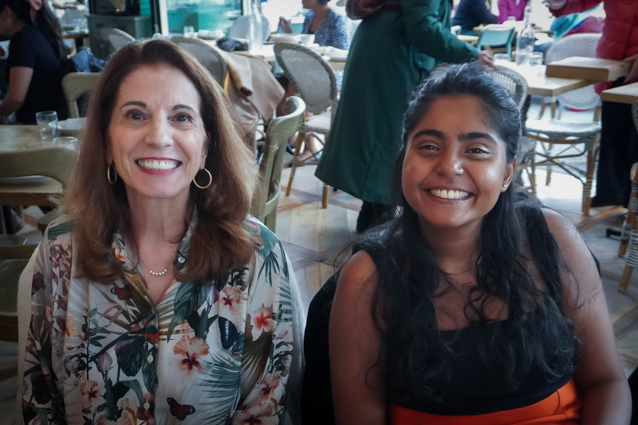 two women smiling at the camera in a restaurant