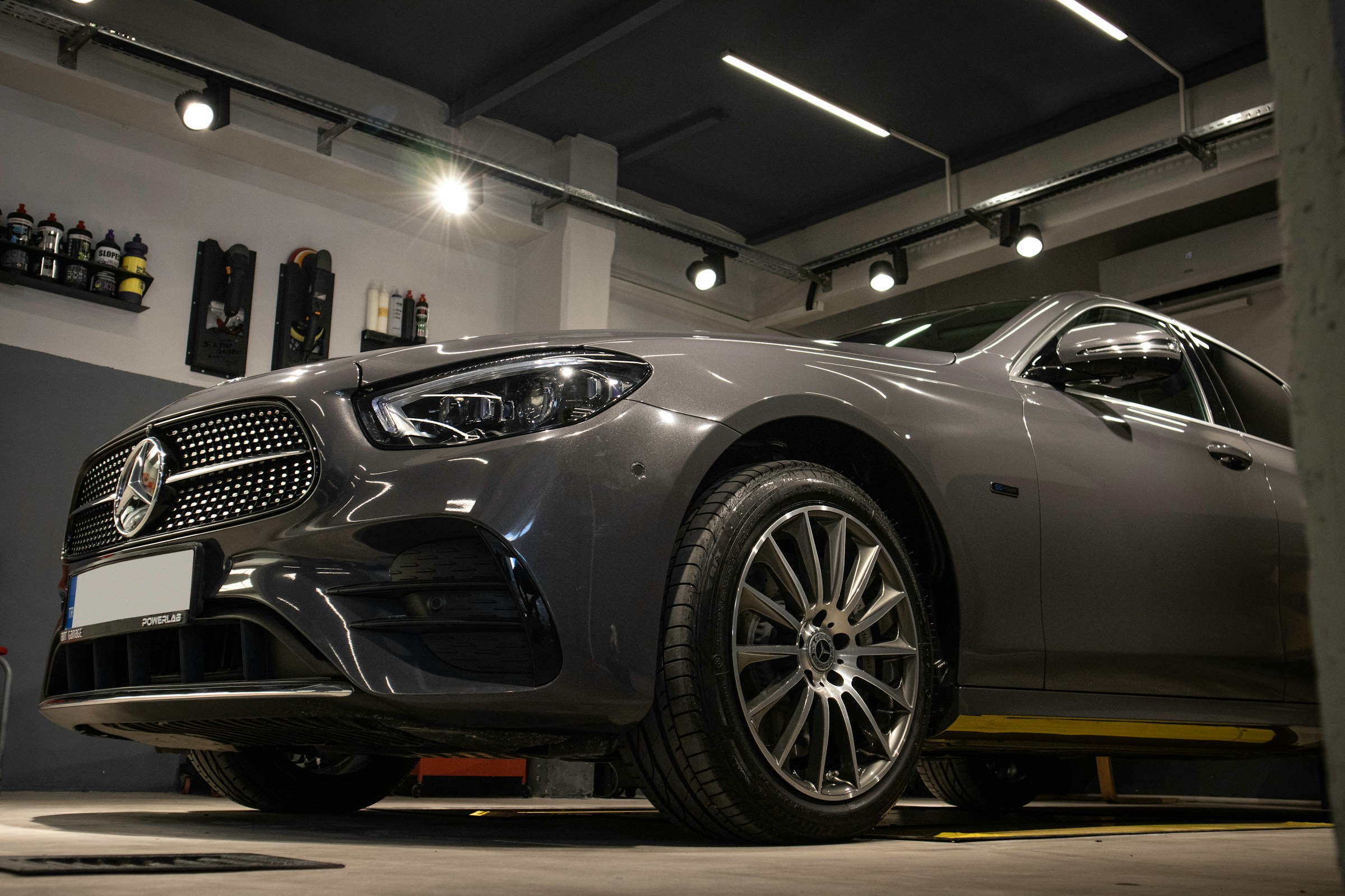 Silver Mercedes sedan displayed inside a clean professional automotive workshop
