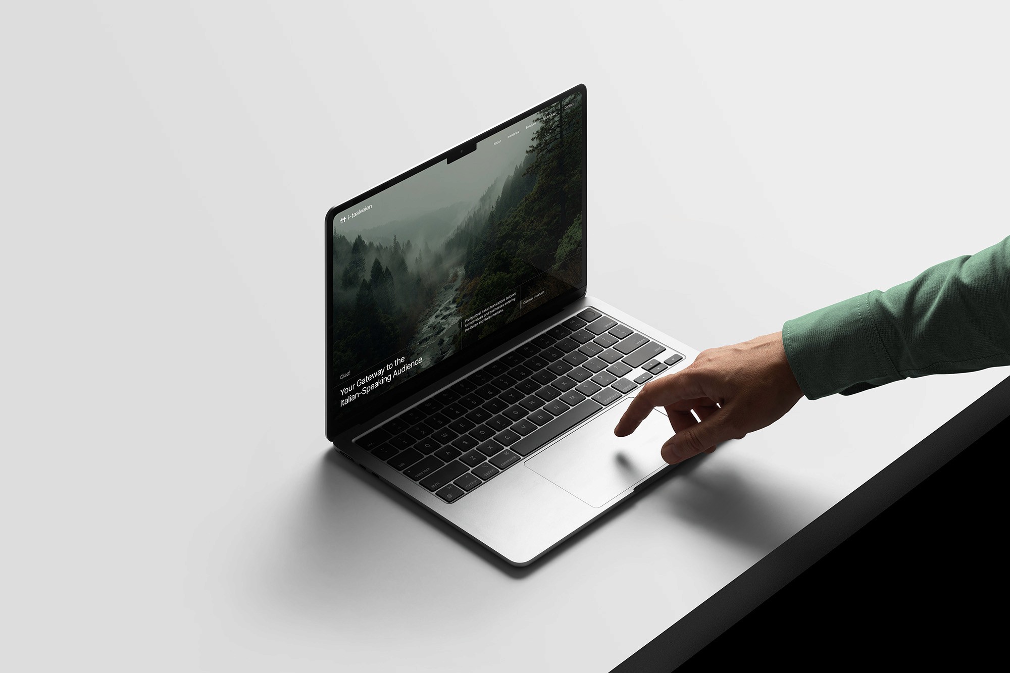 I-taalveien brand through a website layout on a macbook in a minimalist setting