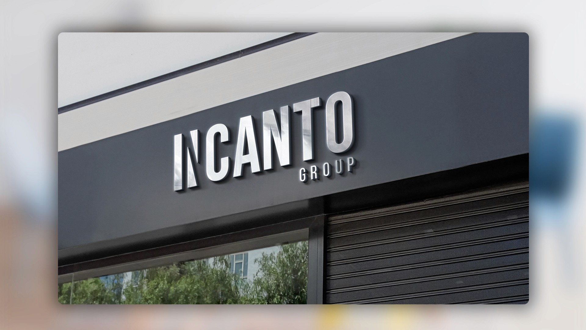 Vidriera moderna con estética minimalista en blanco y negro y letras metálicas de "INCANTO GROUP" sobre el ventanal.