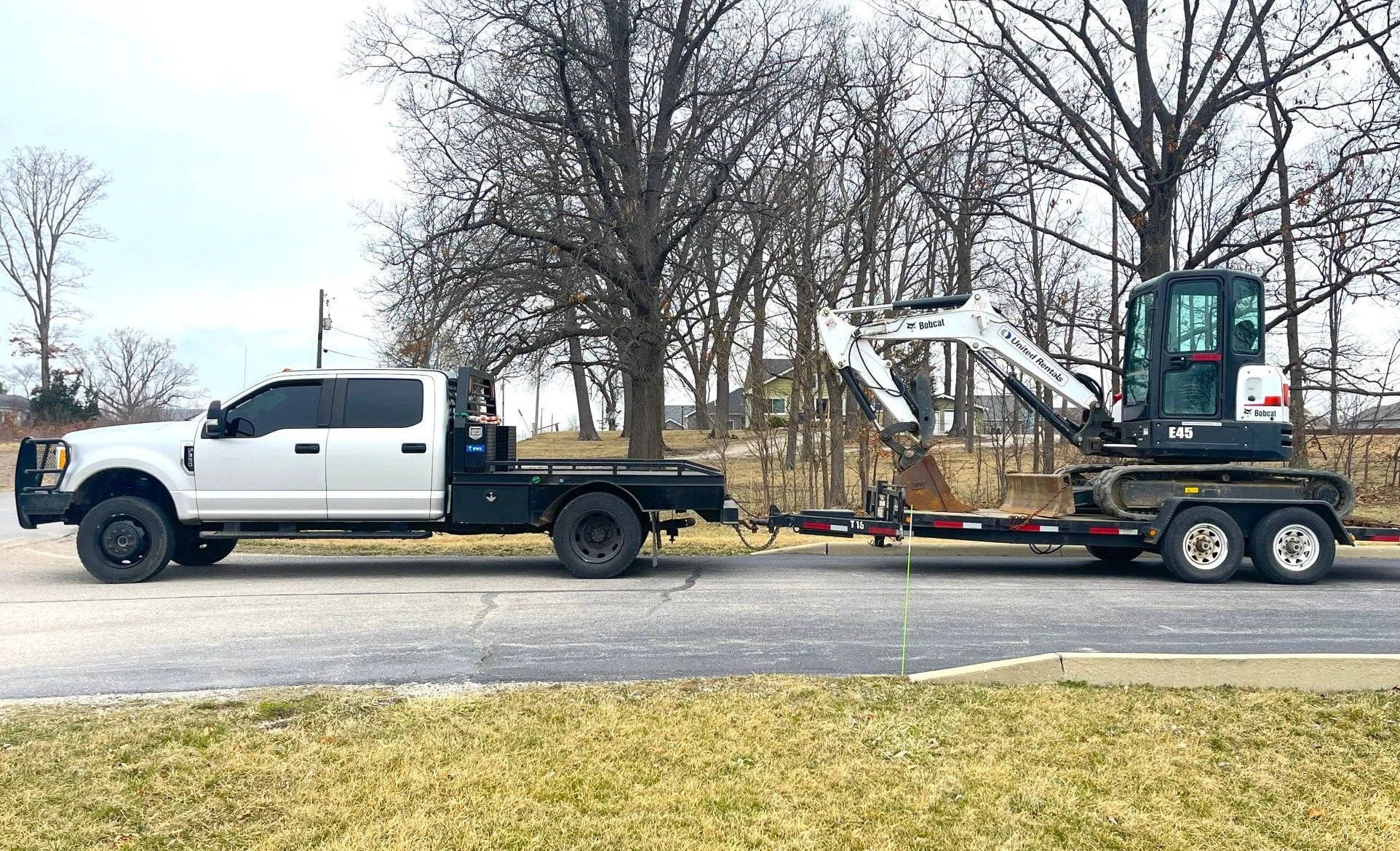 Skid steer loader moving dirt in a wooded area