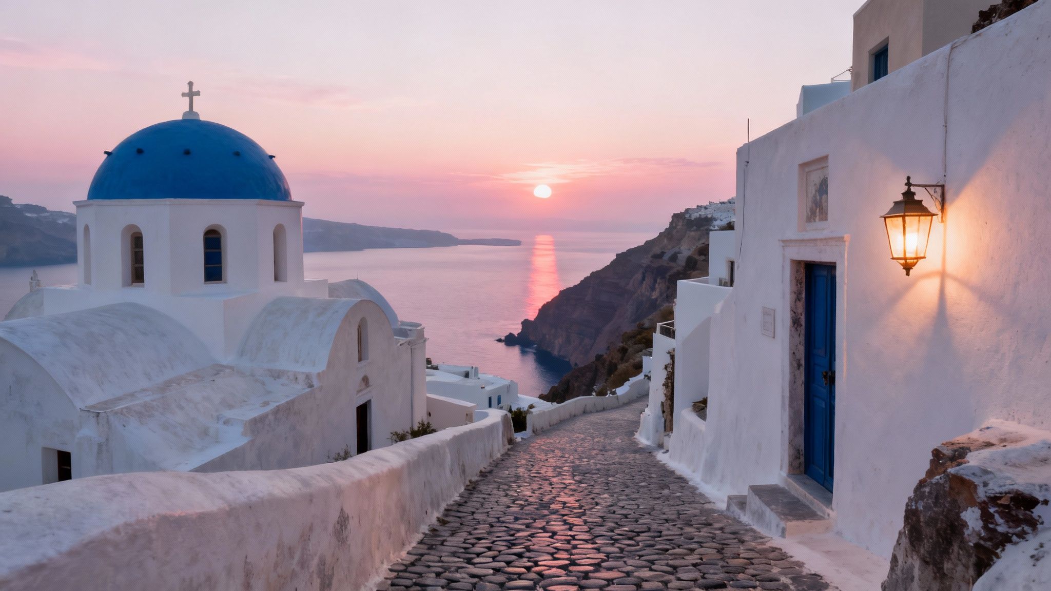 A picturesque sunset in Santorini, Greece, featuring a blue-domed church, white buildings, and a cobblestone path.