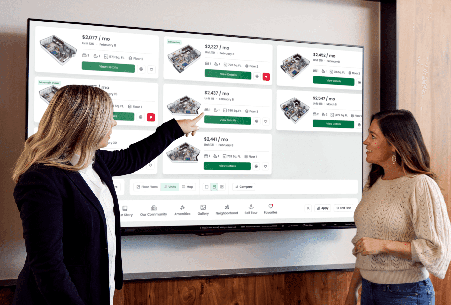 Leasing agent reviewing available units with a resident on a large touchscreen.