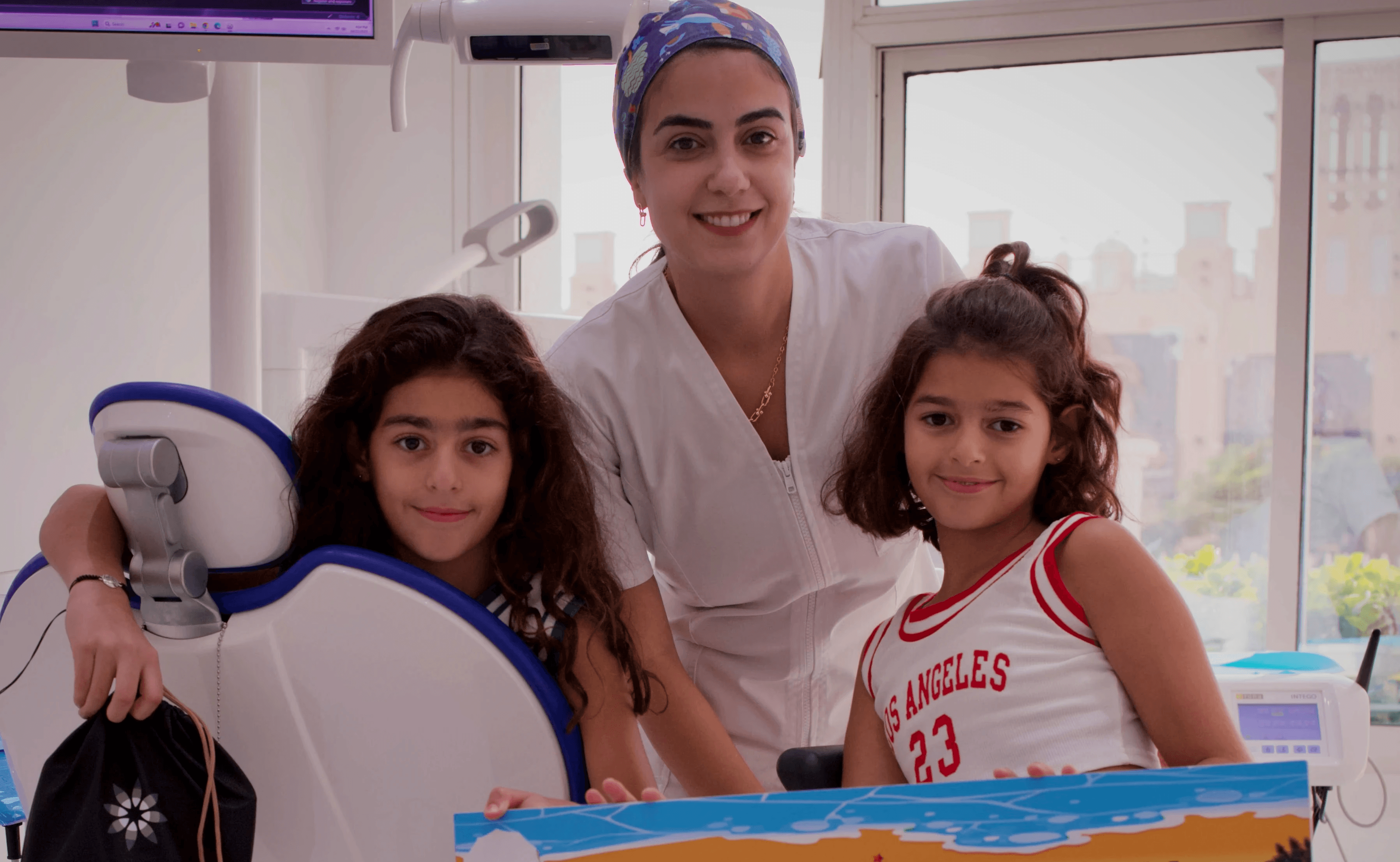 A group photo of a toddler and her sister with an Invisalign Center paediatric dentist, highlighting the importance of care as toddlers get cavities early