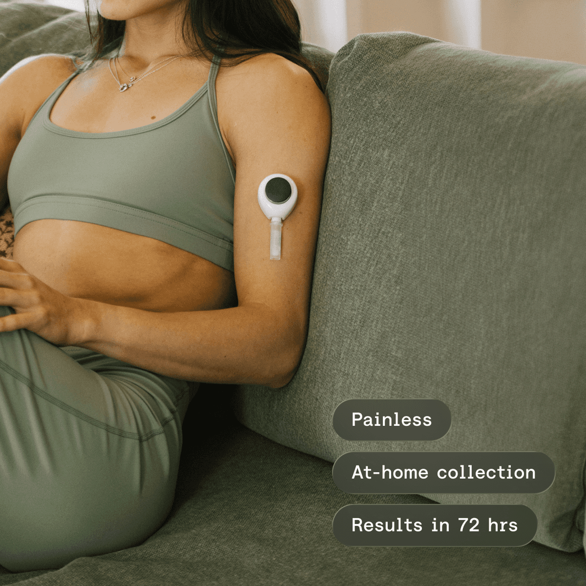 Person sitting on a couch wearing a continuous glucose monitor on the arm, with labels indicating painless use, at-home collection, and results in 72 hours.