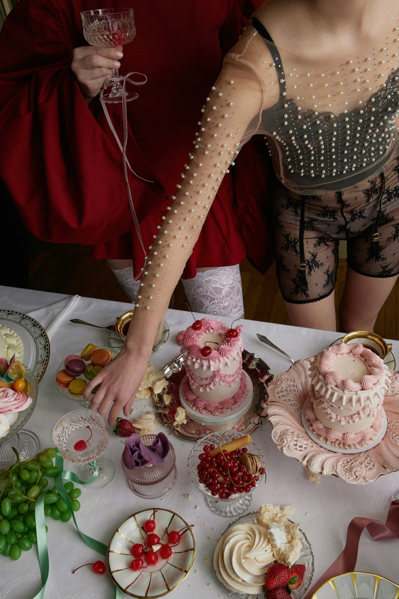 A close-up of a table set with desserts, with hands reaching for sweet treats while enjoying the feast.