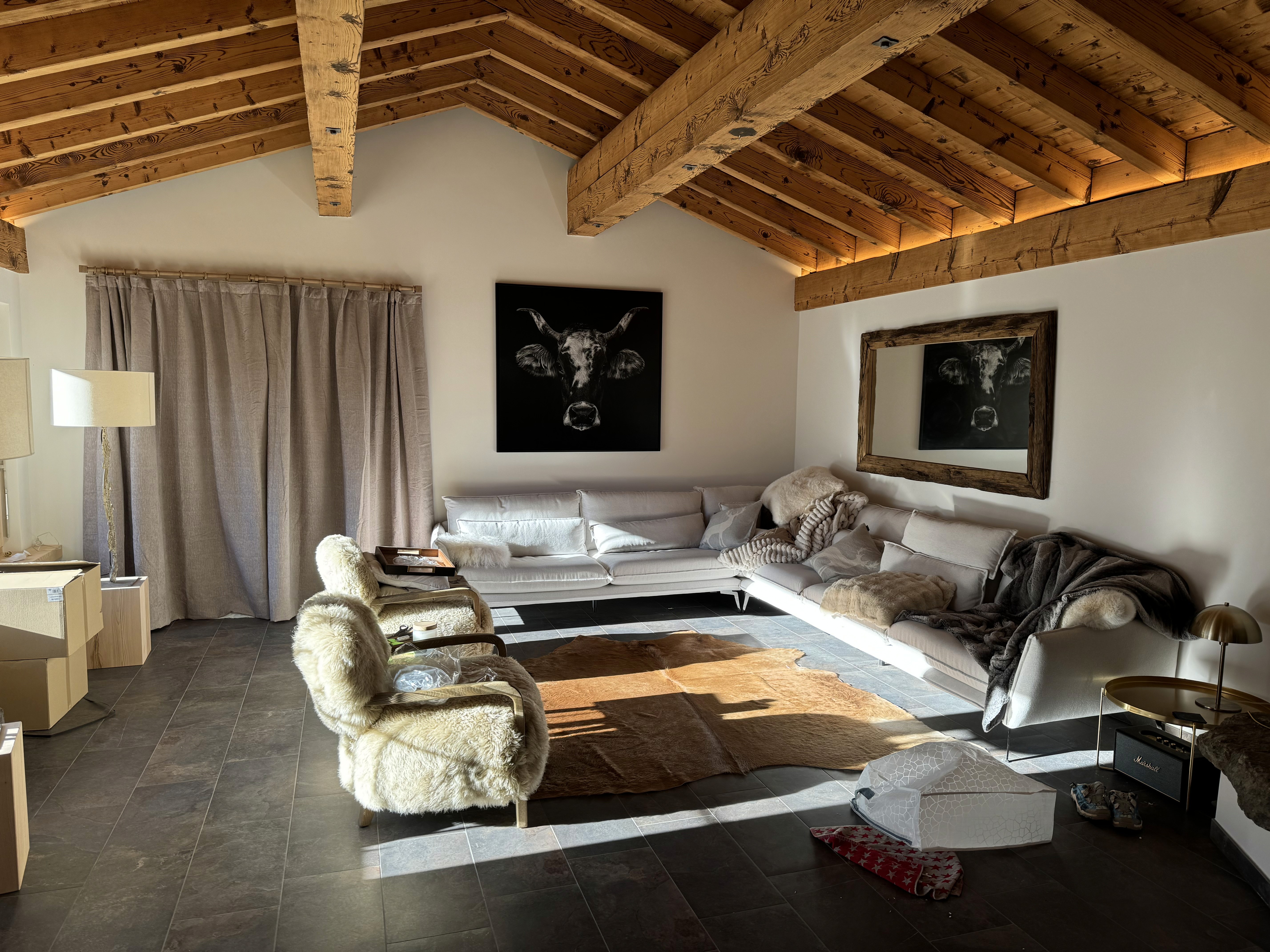 Renovated living room with exposed timber beams, fresh wall finishes and indirect lighting