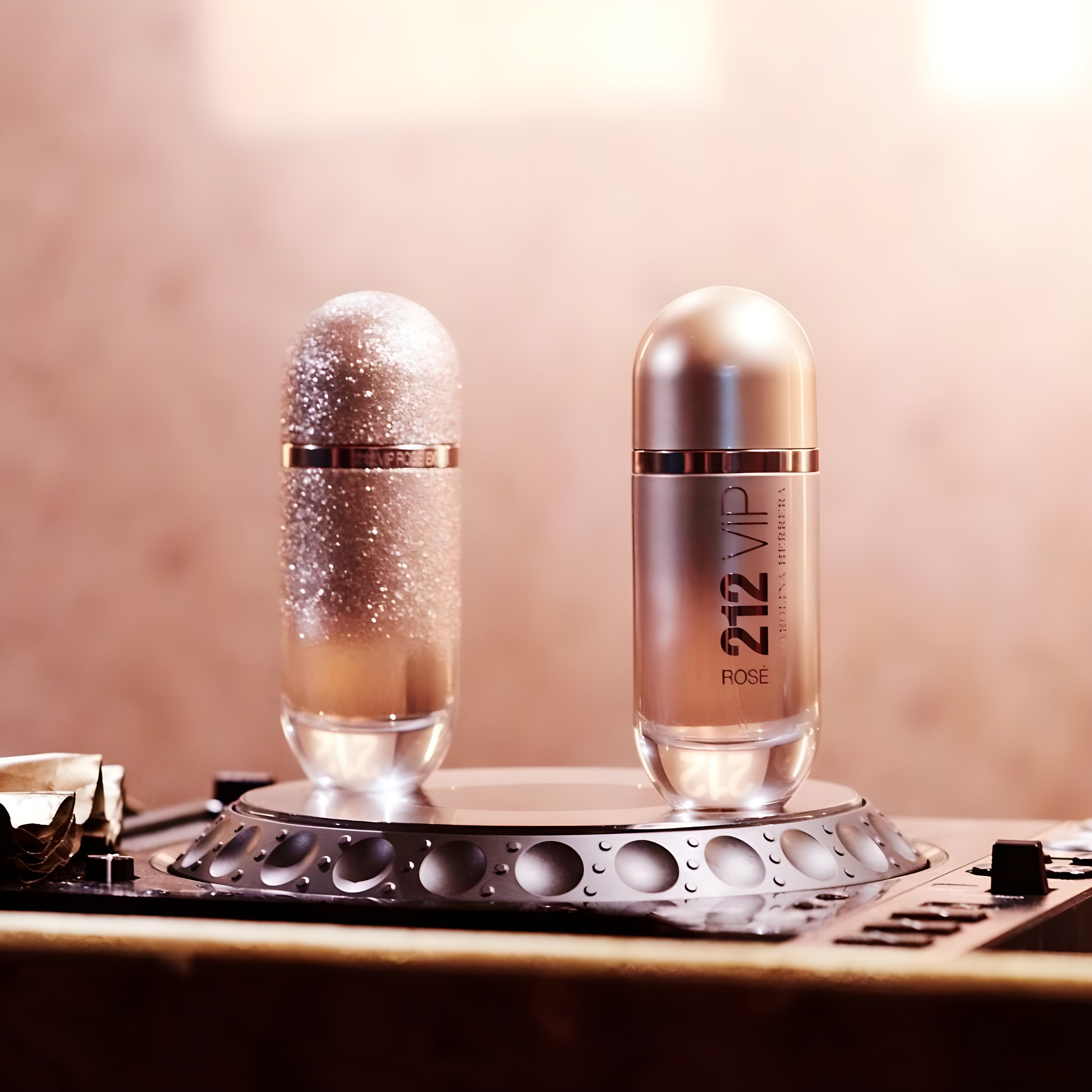 Two rose-gold Carolina Herrera "212 VIP Rosé" perfume bottles sit on a rotating turntable