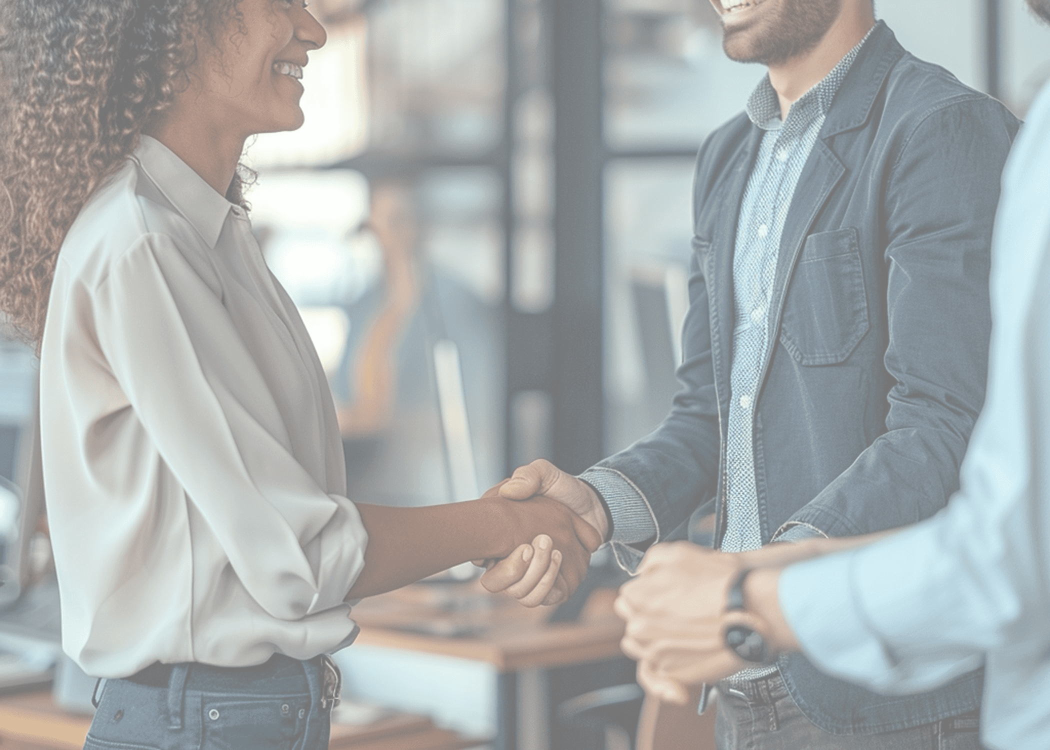 Biracial woman and cacausian man happily shaking hands