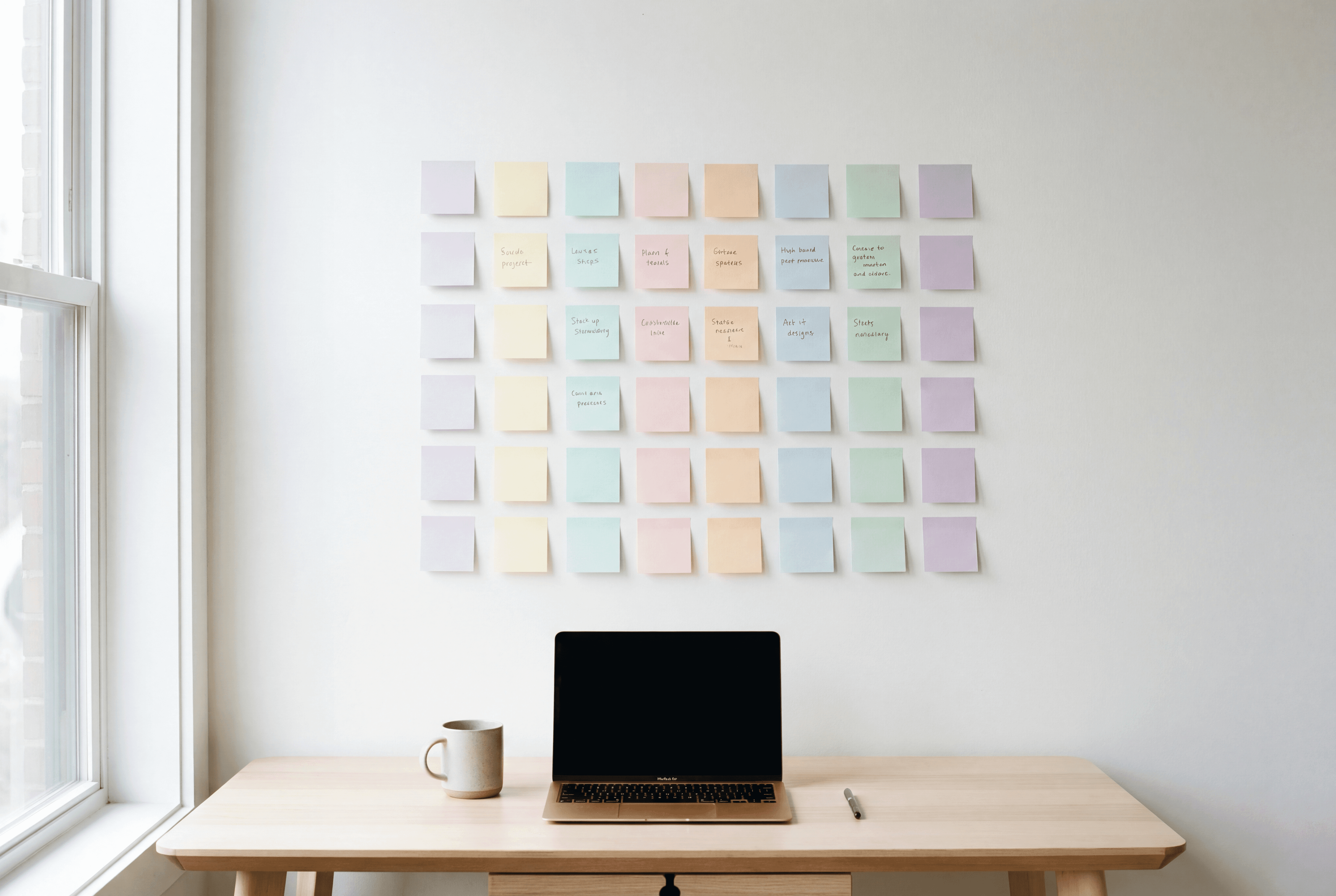 Laptop with notes on the wall for content strategy of social media