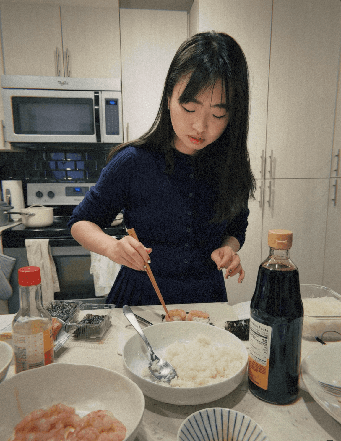 A close-up of a pink cocktail in a martini glass, set against a nighttime background with soft, blurred colors.