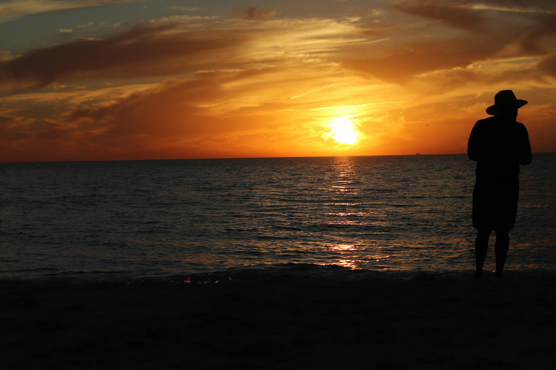 Peaceful sunset over a beach with silhouetted horizon
