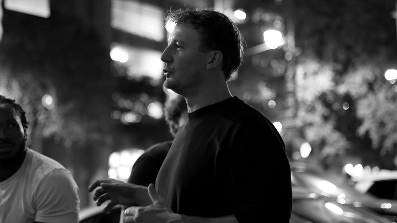 man in black crew neck t-shirt and blue shorts holding woman in white and red