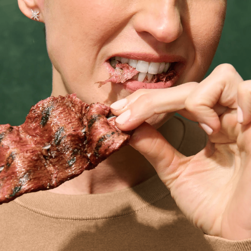 A woman eating bacon.