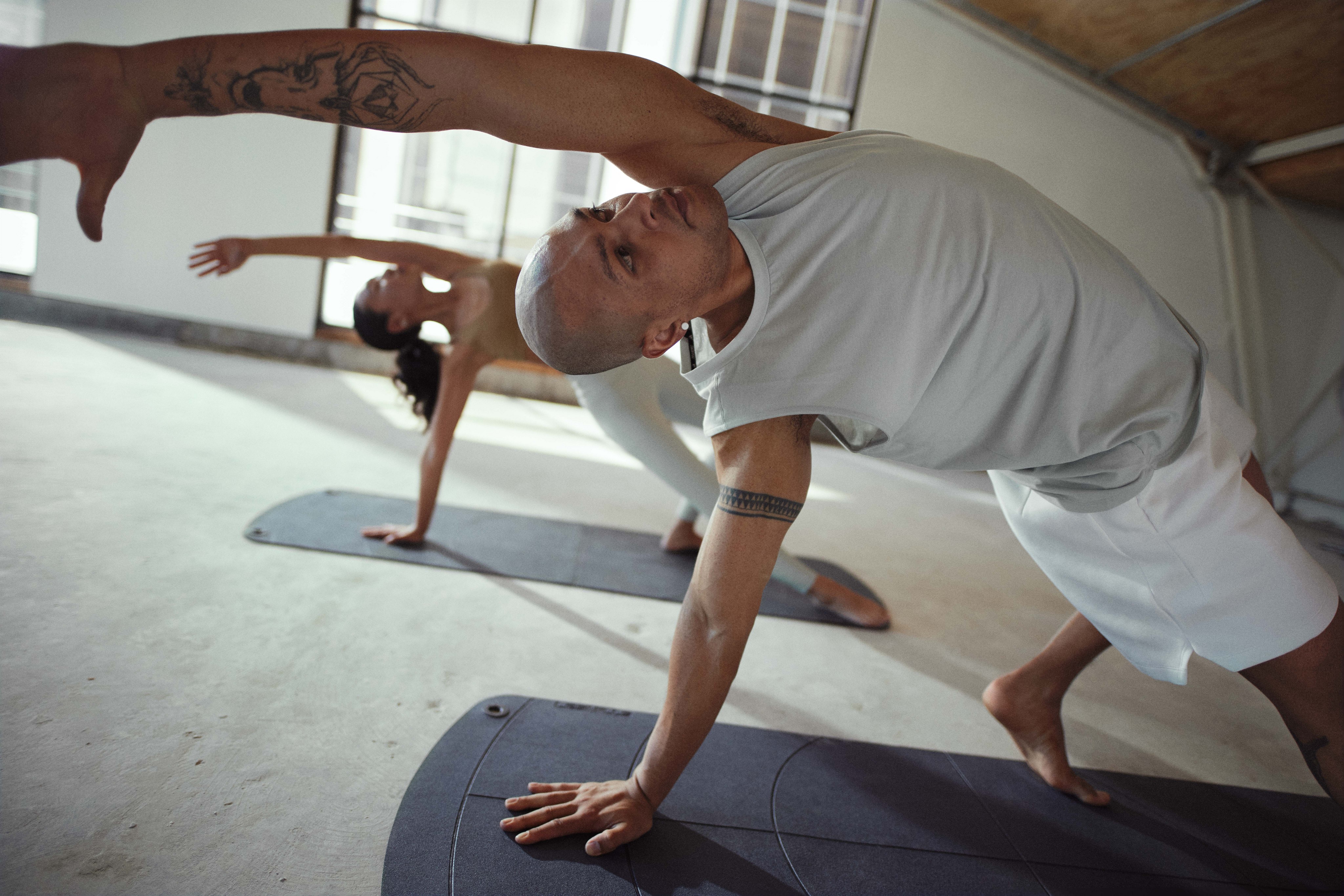 Eine Frau in schwarzer Sportkleidung macht Yoga-Posen während eines Bodybalance-Kurses.