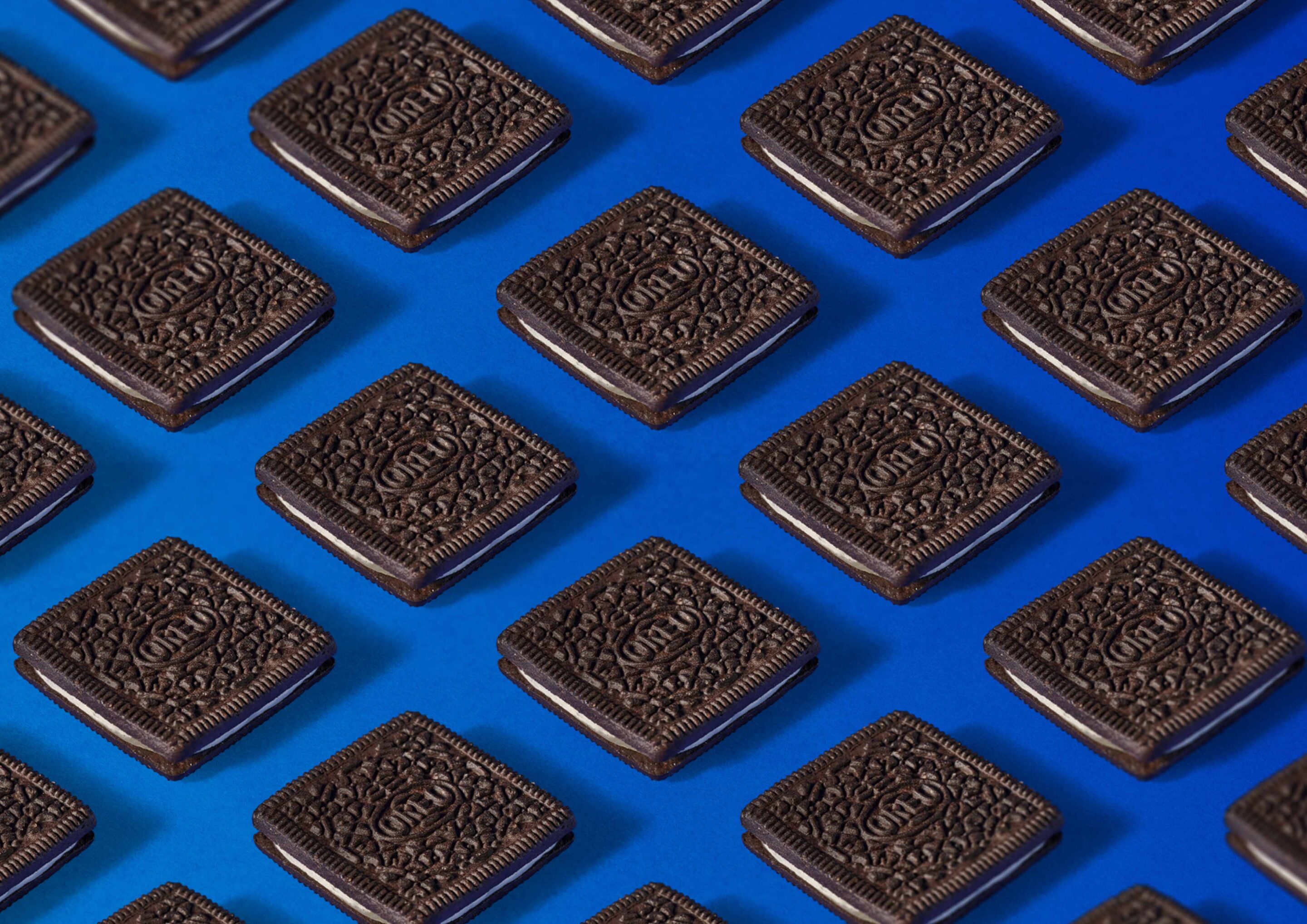 Oreo Kekse in Reihe auf blauem Hintergrund