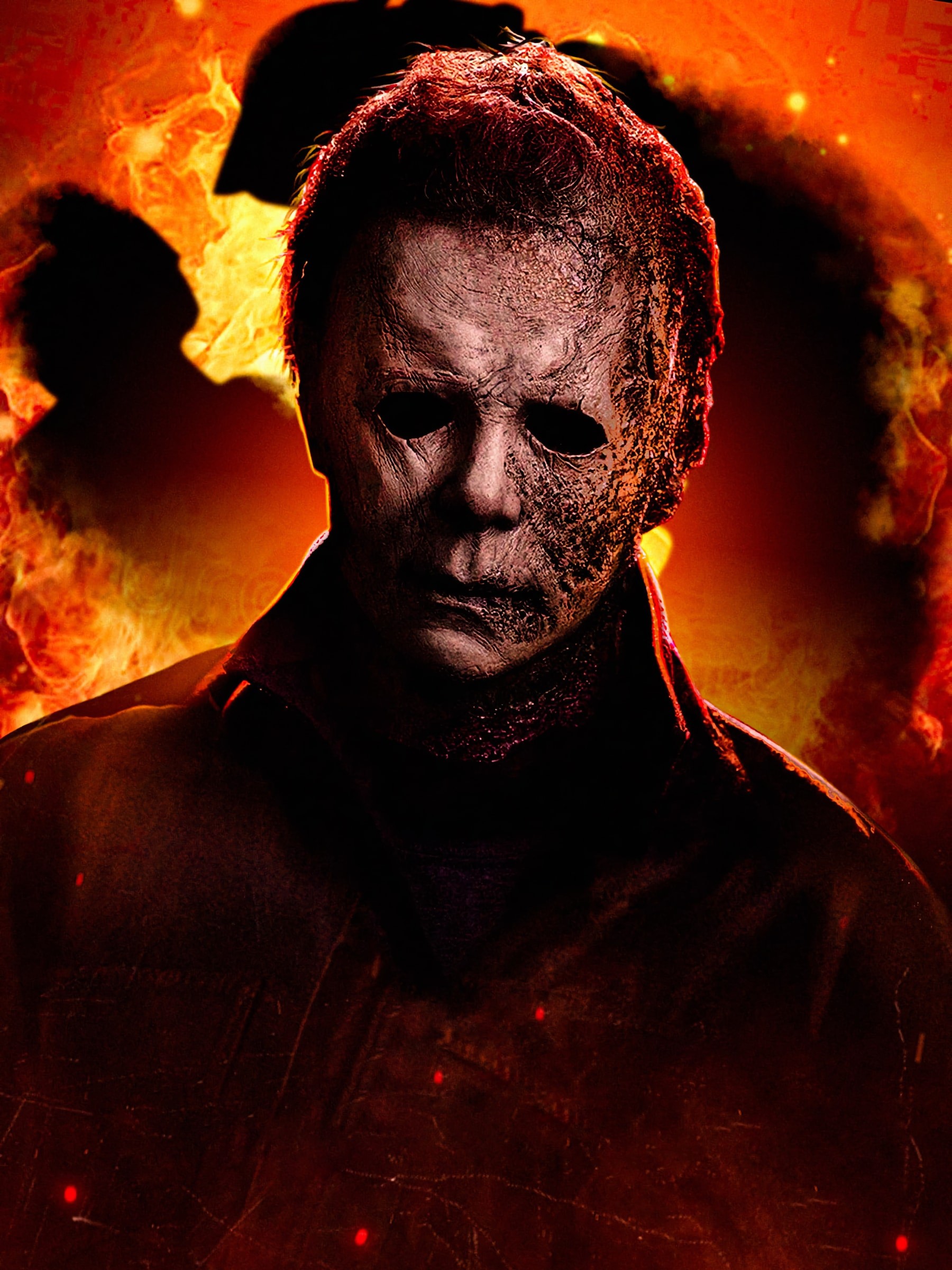 Burned, cracked white-mask figure stands in front of glowing fire and smoke, horror character staring forward.