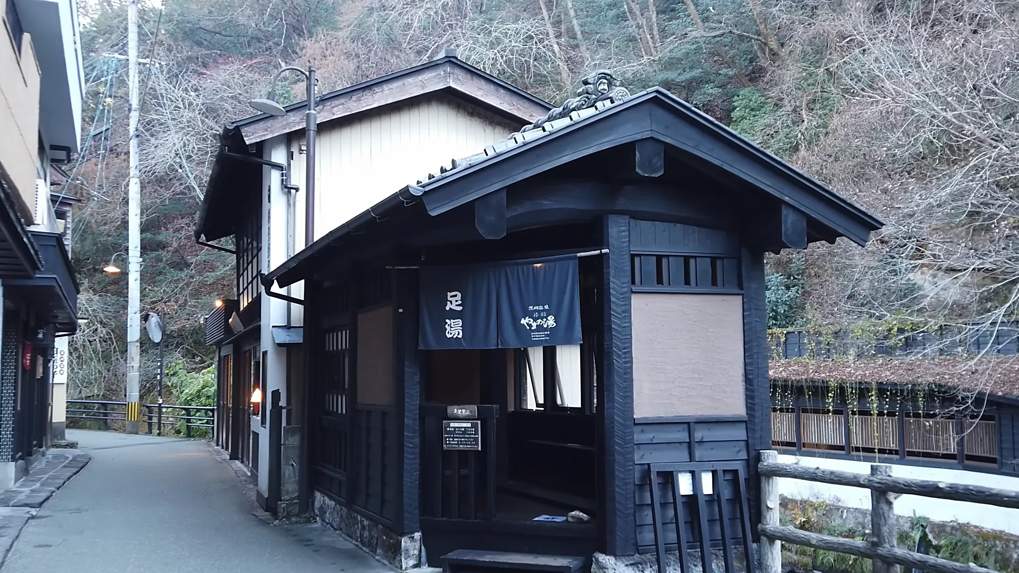 A footbath hut with its noren curtain on a lane in Kurokawa Onsen