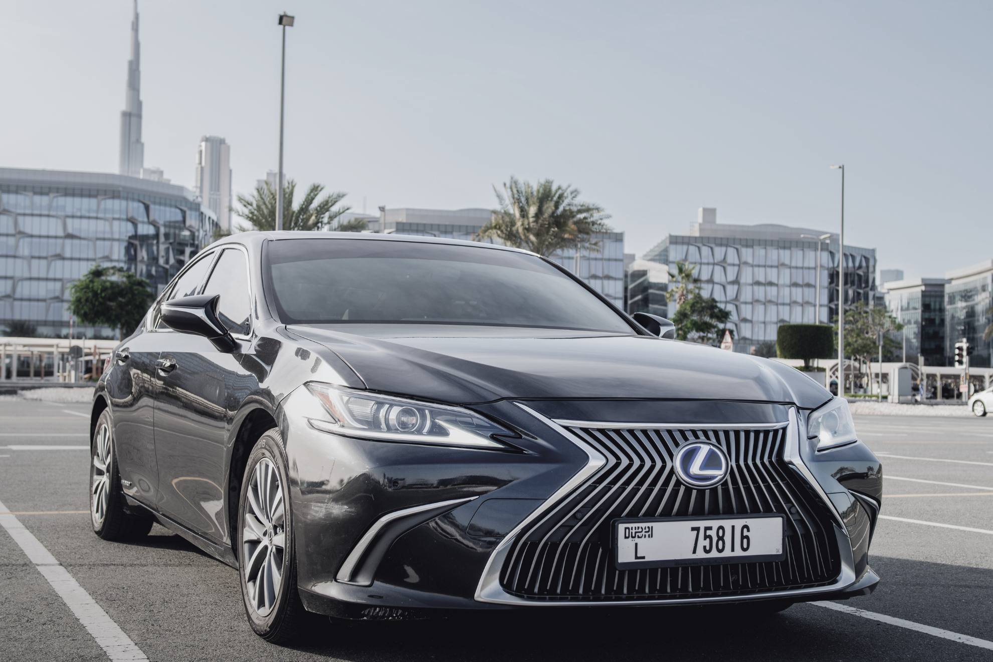 black lexus es in a parking lot with the bhurj khalifa