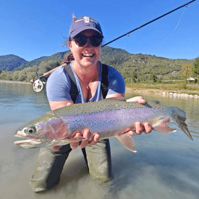 Georgia, Travel Pack Manager at Rod Society, holding a trophy trout — planning world-class fishing trips for fly fishing travelers