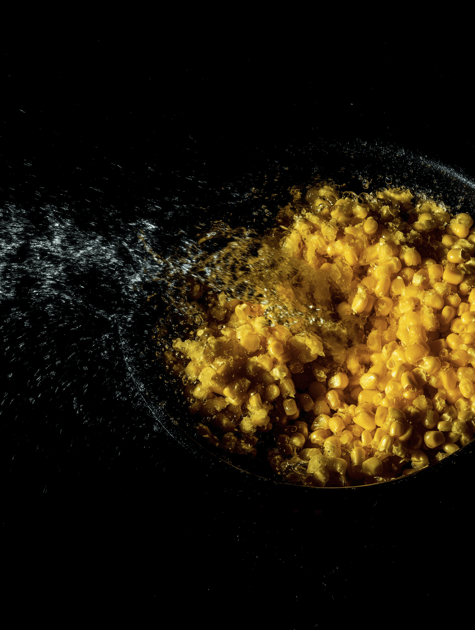 Corn kernels exploding in a dynamic close-up with water splash effect