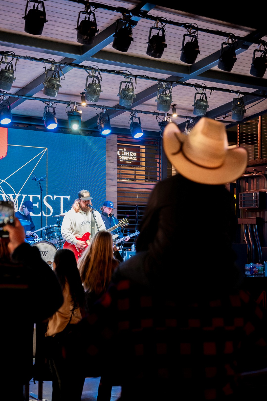Small child sitting on father's shoulders while enjoying a kody west concert.